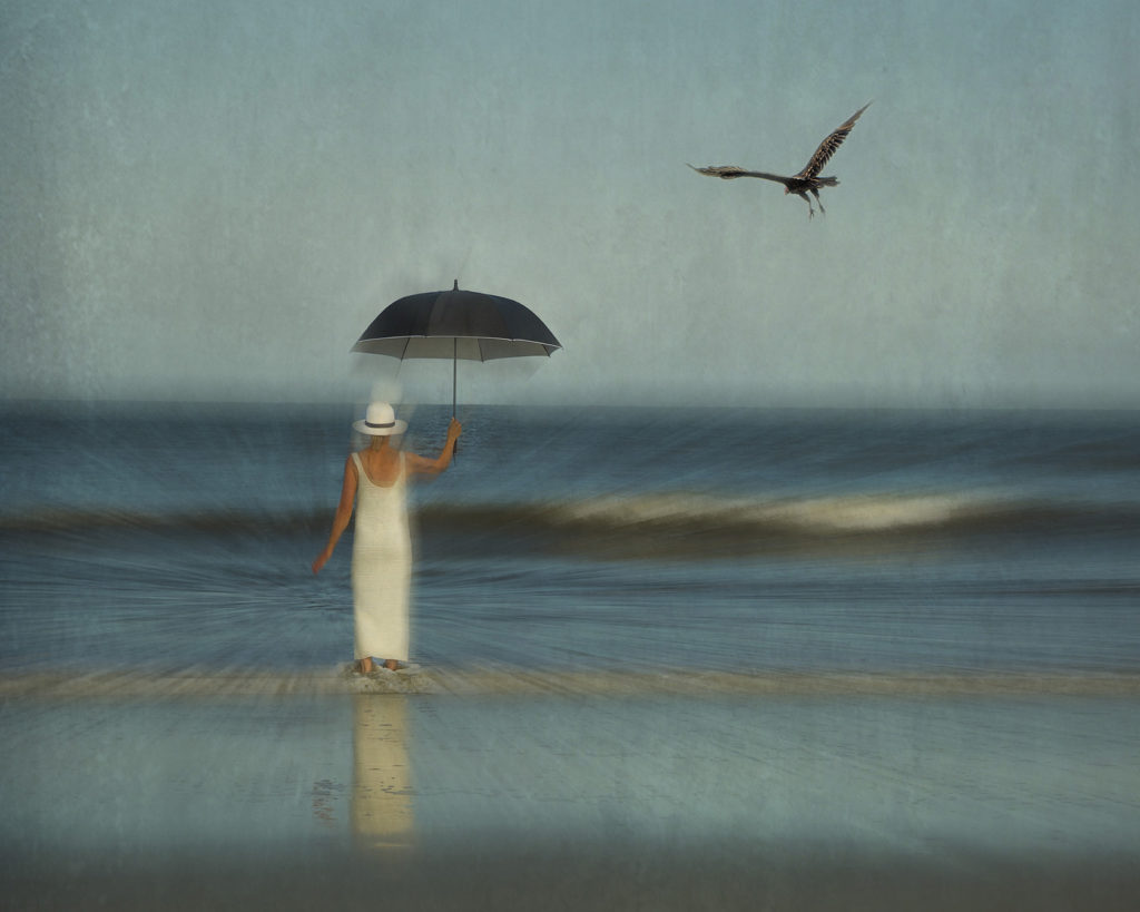 Woman at the shore with Umbrella and a Hawk